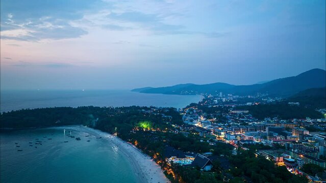 aerial hyperlapse view The lights twinkled along Kata beaches and Karon beach city at night..Kata beach and Karon beach..Bright colors along the beach city area at night..