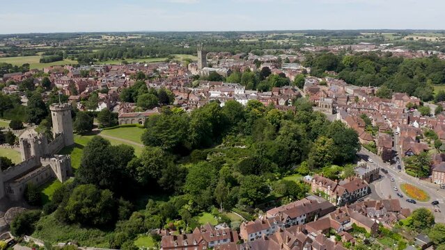 Long sweeping aerial drone shot of the historic Warwick Market Town, Warwickshire in summer, including views of St Mary's Church, Warwick Castle and the River Avon.