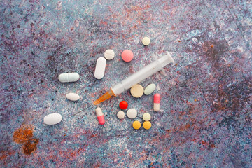 syringe and pills on dark background, close up 
