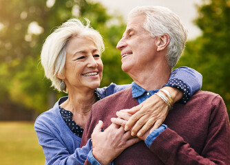 Old couple hug, smile in the park and happiness together outdoor, bonding in nature with love and retirement. Happy, man and woman with travel, relationship with trust in marriage and commitment