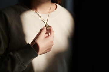 Young woman putting on pedant for event