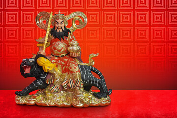front view golden and red chinese prosperity money god sit on a black and grey tiger on gold platform on red floor, red wall background, worship, religion, banner, template, decor, copy space