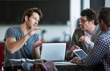 Im thinking about this big.... Cropped shot of three businessman discussing work in the office.