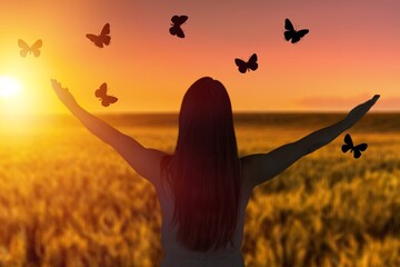 Smiling young woman and flying butterflies
