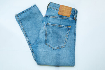 Blue jeans, stack of denim pants, composition, denim texture. top view on white background..
