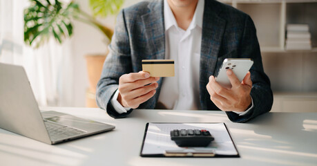 Fototapeta premium Man using smart phone for mobile payments online shopping,omni channel,sitting on table