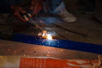 welder working with welding on metal with sparking light