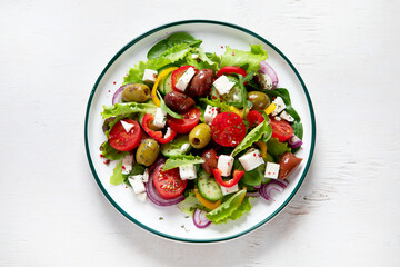 Fototapeta na wymiar Greek village salad horiatiki with feta cheese, olives, cherry tomato, cucumber and red onion, vegeterian mediterranean food, low calories dieting meal.
