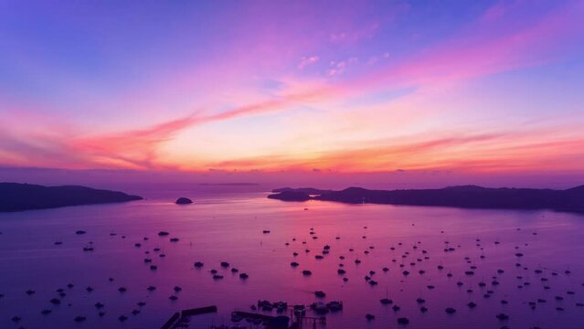 Aerial view Drone hyperlapse of Yacht and sailboat on the pier Chalong bay Phuket thailand,Amazing sunrise sky colorful light of nature over sea,Timelapse sky sunrise