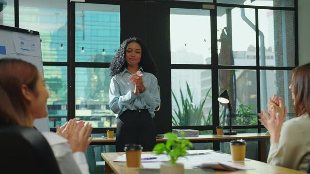 The stunning businesswoman confidently presents her project to the team in a meeting room, leaving everyone in awe of her presentation and eliciting a round of applause.