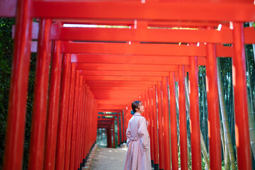 赤い鳥居をくぐる女性