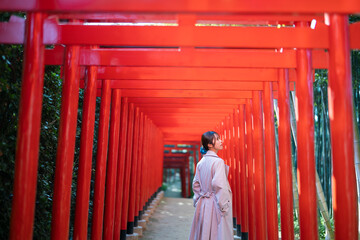 赤い鳥居をくぐる女性