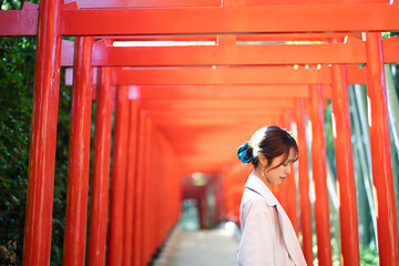赤い鳥居をくぐる女性
