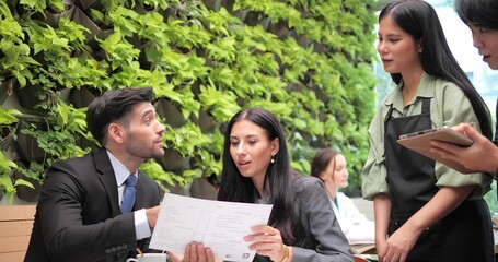 Two businessmen in elegant suits talk and take orders at a cafe and restaurant