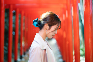 赤い鳥居をくぐる女性