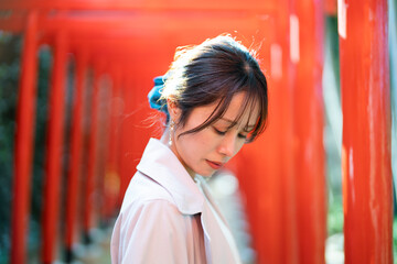 赤い鳥居をくぐる女性