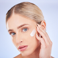 Skincare, face portrait and woman with cream in studio isolated on a blue background. Dermatology...