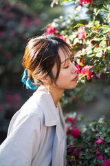 Naklejka premium 赤い花の咲く公園を散策する女性