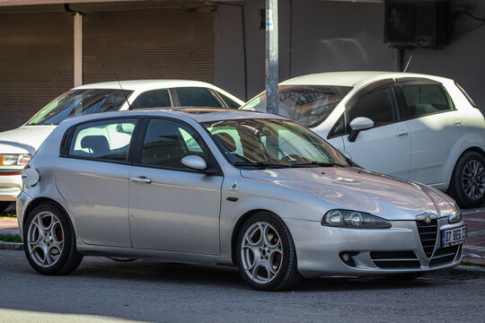 Side, Turkey &ndash; February 05 2023: white Alfa Romeo  147  is parked  on the street on a warm day