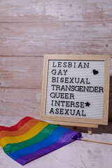 LGBTQIA description frame on Rainbow LGBTQIA flag made from silk material. LESBIAN, GAY, BISEXUAL,...