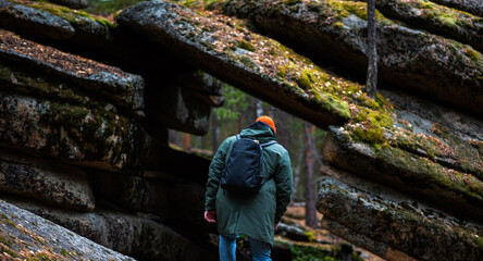 A tourist enjoys the beautiful scenery in northern Finland. Panorama of the autumn pine forest with formation rocks and faults. Northern nature. Nature of Finland autumn. Tourism northern landscape.