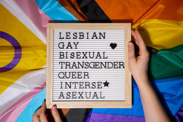 LGBTQIA description frame on Rainbow LGBTQIA flag made from silk material. LESBIAN, GAY, BISEXUAL,...