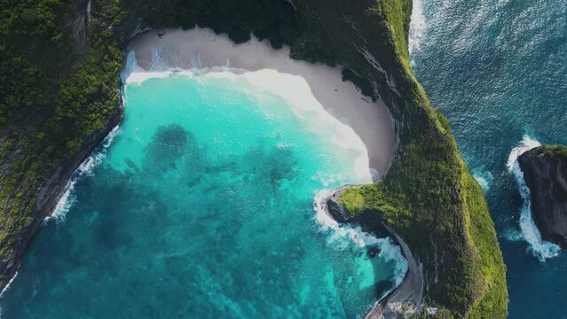 Nusa Penida kelingking beach bali t-rex dinosaur drone aerial top flying above view famous place in Asia indonesia colorful jurassic park green cliffs deep blue waves beautiful paradise environment