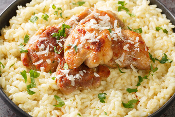 Arborio rice with parmesan and garlic served with fried chicken close-up in a plate on the table. Horizontal