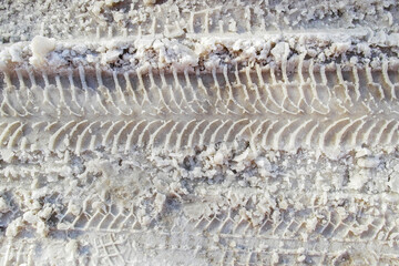 Car tire tracks in the snow. Dirty snow spring background. Spring time. Old snow