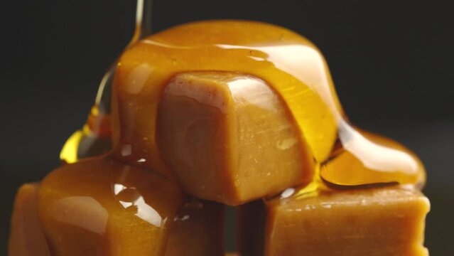 caramel dripping.toffee sauce dripping on black background,caramel sweet snack 