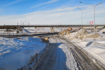 Fototapeta premium One of the streets of the city. Urban landscape. Springtime. Melting snow. City outskirts. New residential area. Ust-Kamenogorsk (kazakhstan)
