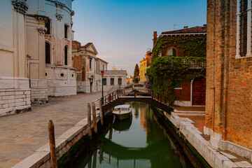 Naklejka premium A canal in venice with a bridge and a boat on it