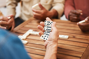 Hands, dominoes and friends in board games on wooden table for fun activity, social bonding or...