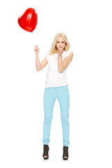 A beautiful woman holding a red heart balloon in the air and blowing kisses on her beloved and celebrating the romantic event of valentine's day isolated on a png background.