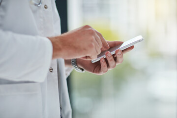 Its one way to keep patients informed. Closeup shot of an unrecognisable doctor texting on his cellphone.