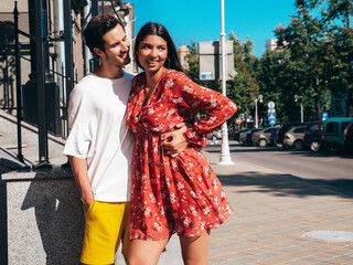 Naklejka premium Smiling beautiful woman and her handsome boyfriend. Happy cheerful family. Sexy couple posing in the street at sunrise. During romantic date at sunny summer day outdoors. Looking at each other