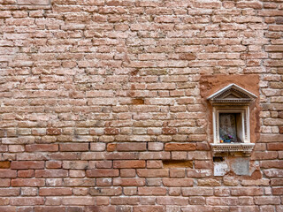 Fototapeta na wymiar Religious niche in traditional brick textured wall background in design loft style. Grunge reddish brown colored with copy space. Blank poster or wallpaper surface template. Partly damaged pattern.