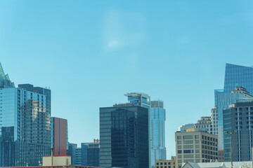 Fototapeta na wymiar Downtown austin texas with office building and reflective glass with blue and hazy white sky in afternoon sun midday