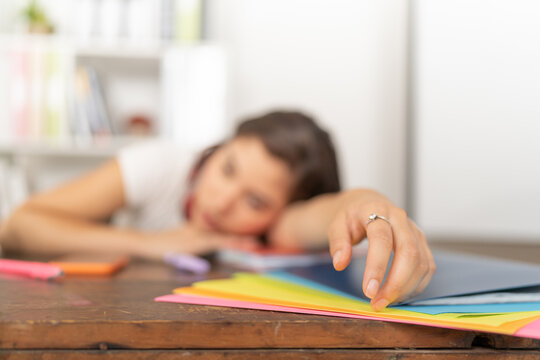 Young woman, lying on the desk with rings on her fingers and her arm stretched