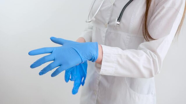 Close up Scientist hands putting in nitrile blue latex gloves in labcoat wearing nitrile gloves, doing experiments in lab. High quality photo
