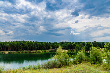 View on a lake in the abandoned sand quarry and dramatic sky