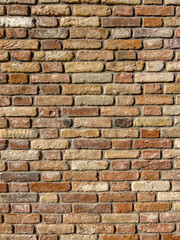 Vertical traditional brick textured wall background in design loft style. Grunge reddish brown colored with copy space. Blank poster or wallpaper surface template. Partly damaged pattern.