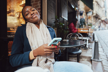 Young african woman using smart phone in a modern cafe