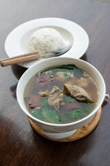 Pork blood tofu soup with gourd leaves,Clear soup asian style food mixed minced pork balls,
Pork blood cubes and liver in with bowl,Healthy and Rich in iron and protein