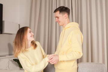 Beautiful couple in yellow clothes talking and laughing