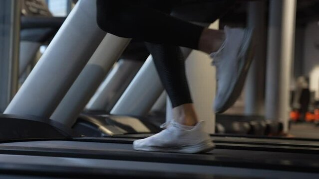 Athlete running on fitness treadmill in gym. Treadmill workout of athlete. Fitness gym equipment.