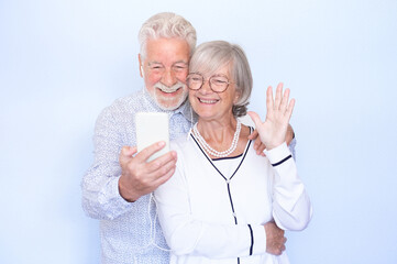 Video call concept. Happy senior couple laughing using smartphone together for video chat online communication, man and woman expressing happiness and positive emotions