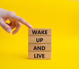 Wake up and live symbol. Wooden blocks with words Wake up and live. Beautiful yellow background....