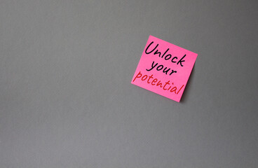 Unlock your Potential symbol. Concept words Unlock your Potential on pink steaky note. Beautiful grey background. Business and Unlock your Potential concept. Copy space.