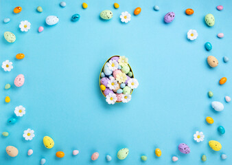 Easter Eggs with Sweets and Spring Flowers on Blue Background